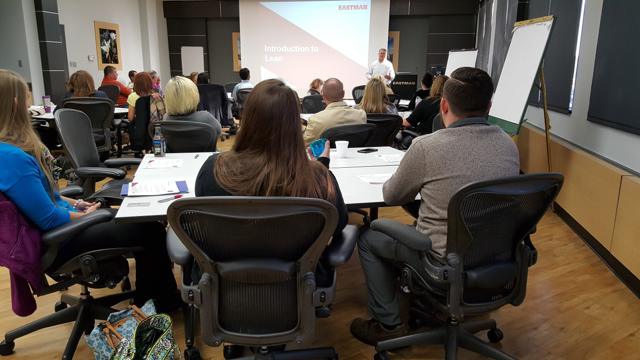 Attendees at tables facing the presenter