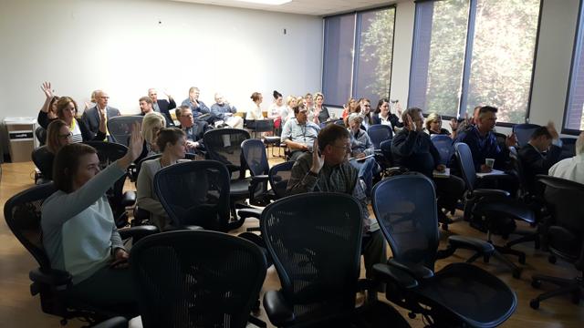 Attendees raising hands during a breakout session